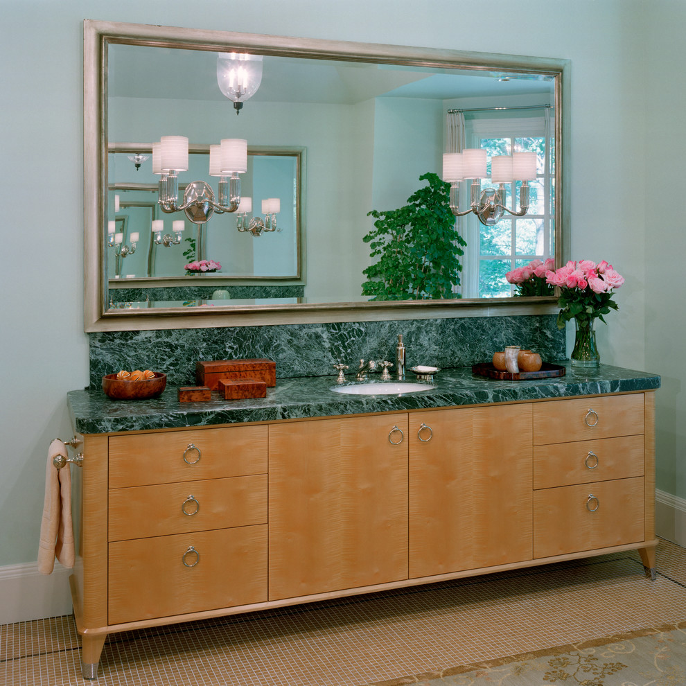 Modelo de cuarto de baño tradicional con armarios tipo mueble, puertas de armario de madera clara, encimera de mármol, bañera exenta, baldosas y/o azulejos beige y baldosas y/o azulejos de vidrio