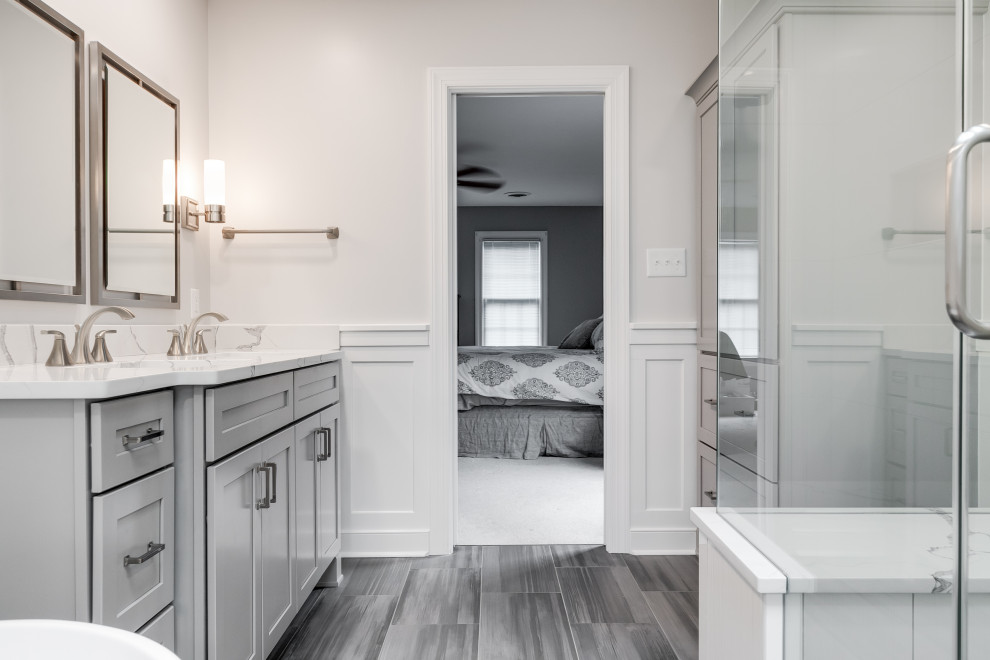 Bathroom - large traditional master white tile and ceramic tile porcelain tile and gray floor bathroom idea in Richmond with recessed-panel cabinets, gray cabinets, a two-piece toilet, gray walls, an undermount sink, quartzite countertops, a hinged shower door and white countertops