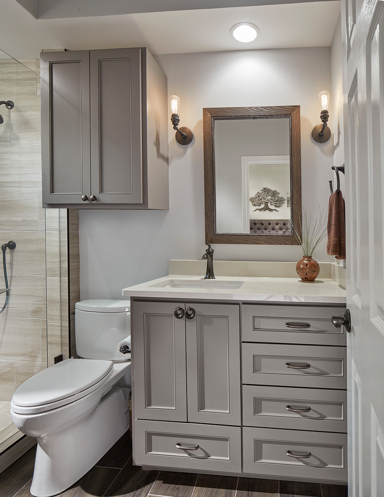 Foto di una piccola stanza da bagno tradizionale con WC a due pezzi, piastrelle beige, pareti grigie, pavimento marrone, porta doccia a battente e top beige