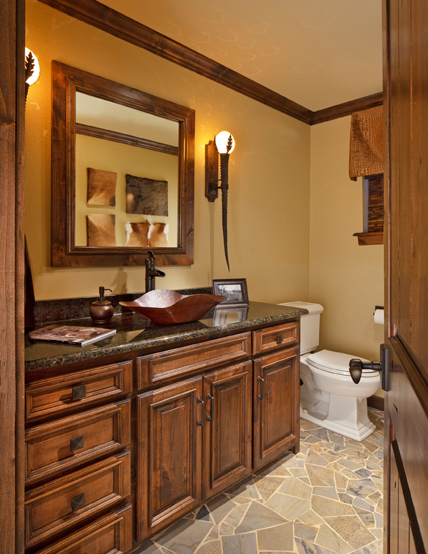 Immagine di una stanza da bagno tradizionale con ante con bugna sagomata, ante in legno scuro, top in granito e piastrelle multicolore