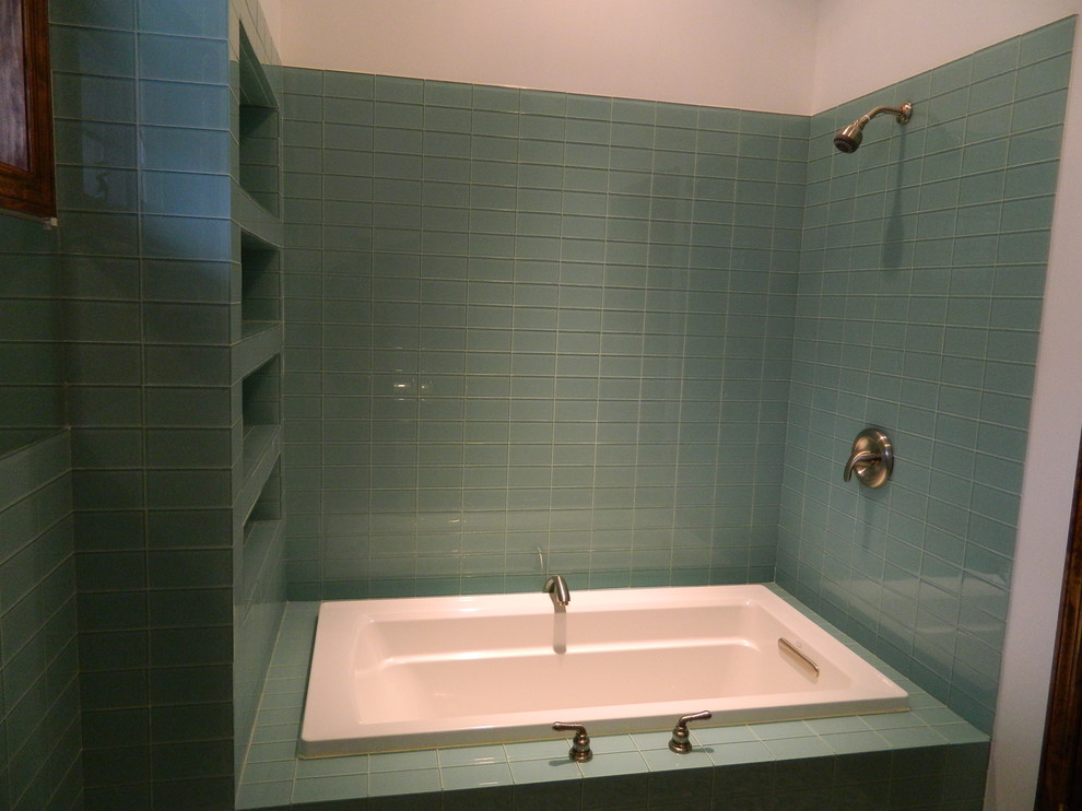 Cette photo montre une salle de bain tendance avec une baignoire posée, un combiné douche/baignoire, un carrelage vert et un carrelage en pâte de verre.