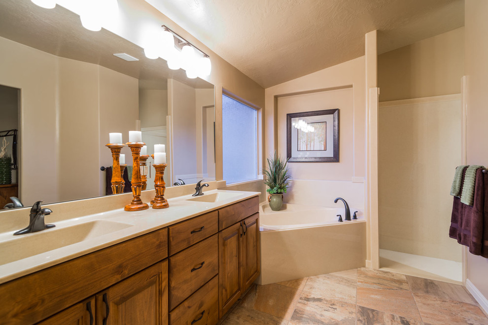 Bathroom - large traditional master limestone floor bathroom idea in Salt Lake City with raised-panel cabinets, dark wood cabinets, beige walls, an integrated sink and laminate countertops