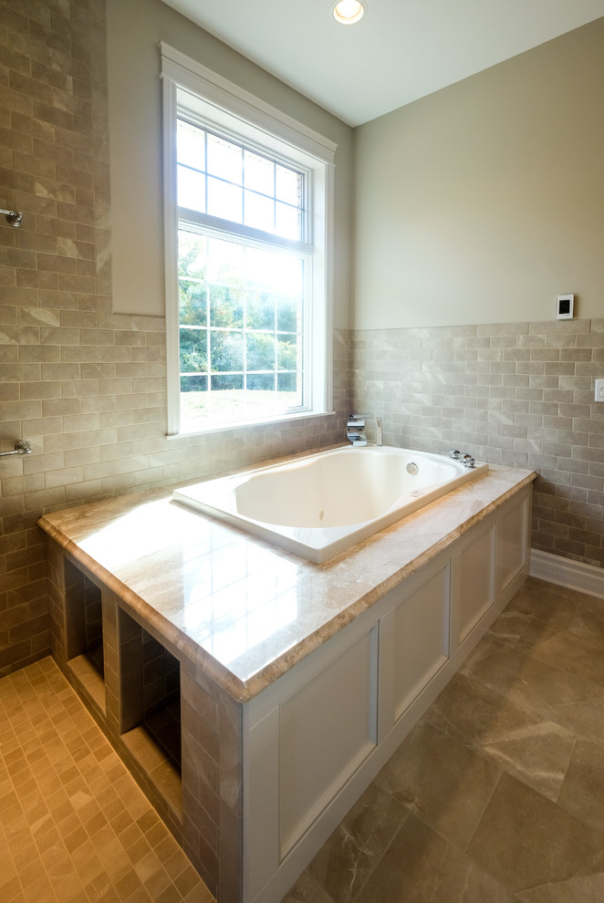 Cette photo montre une grande salle de bain principale chic avec un placard avec porte à panneau encastré, des portes de placard blanches, un mur beige, un lavabo encastré, un plan de toilette en marbre et un sol beige.