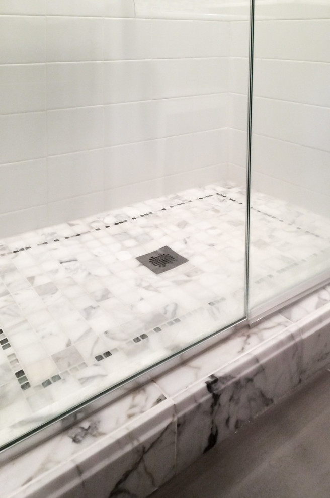 Cette image montre une salle de bain principale traditionnelle de taille moyenne avec un carrelage multicolore, mosaïque, un mur gris, un sol en carrelage de porcelaine, un lavabo encastré, un plan de toilette en marbre, un sol gris et une cabine de douche à porte battante.