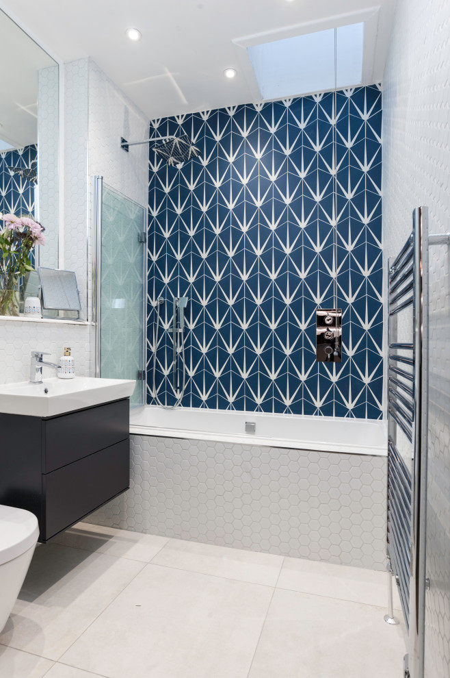 Exempel på ett modernt badrum, med släta luckor, svarta skåp, ett badkar i en alkov, en dusch/badkar-kombination, blå kakel, ett konsol handfat, grått golv och med dusch som är öppen