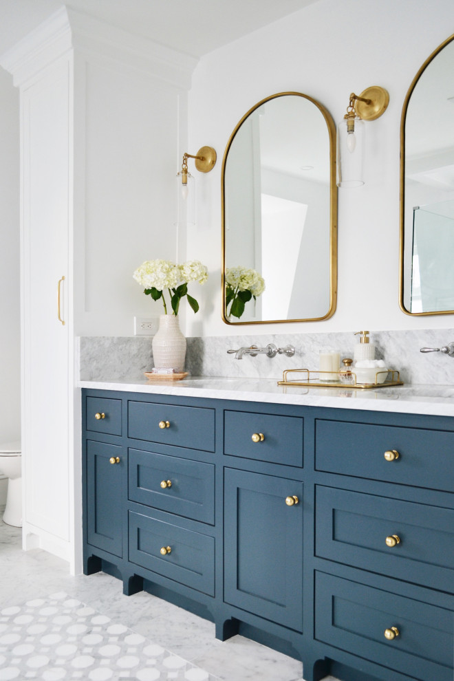 Cette image montre une salle de bain traditionnelle avec un placard à porte shaker, des portes de placard bleues, un mur blanc, un lavabo encastré, un sol gris, un plan de toilette blanc et meuble double vasque.