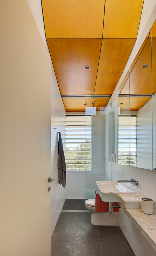 Стильный дизайн: узкая и длинная ванная комната в современном стиле с подвесной раковиной, серой плиткой и душем без бортиков - последний тренд