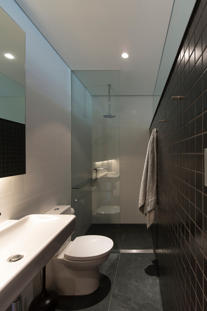 Esempio di una stretta e lunga stanza da bagno contemporanea con doccia aperta, WC a due pezzi, lavabo rettangolare, pavimento nero e doccia aperta