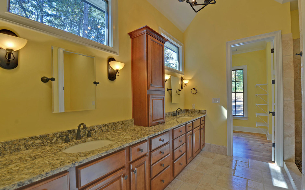 Пример оригинального дизайна: большая главная ванная комната в стиле кантри с фасадами с выступающей филенкой, фасадами цвета дерева среднего тона, открытым душем, раздельным унитазом, бежевой плиткой, плиткой из травертина, желтыми стенами, полом из травертина, врезной раковиной, столешницей из гранита, бежевым полом и шторкой для ванной