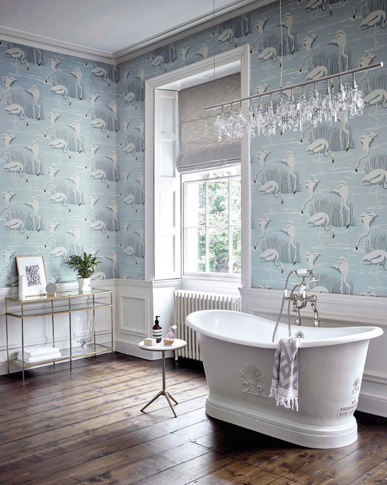 Idée de décoration pour une salle de bain principale tradition avec une baignoire indépendante, un mur bleu, parquet foncé, du lambris, du papier peint et un sol marron.