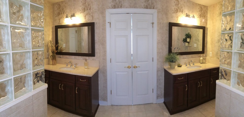 Example of a large classic master beige tile vinyl floor bathroom design in Richmond with raised-panel cabinets, dark wood cabinets, beige walls and an undermount sink