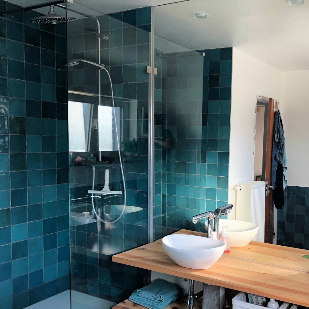 Inredning av ett 60 tals mellanstort en-suite badrum, med en kantlös dusch, en toalettstol med hel cisternkåpa, perrakottakakel, vinylgolv, ett fristående handfat, träbänkskiva och med dusch som är öppen