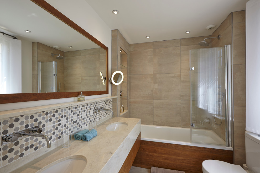 Foto di una stanza da bagno con doccia mediterranea con vasca/doccia, piastrelle beige, pareti beige e lavabo integrato