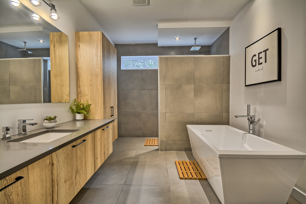 Bathroom - mid-sized scandinavian master gray tile and porcelain tile porcelain tile and gray floor bathroom idea in Montreal with flat-panel cabinets, medium tone wood cabinets, a one-piece toilet, gray walls, an undermount sink and solid surface countertops