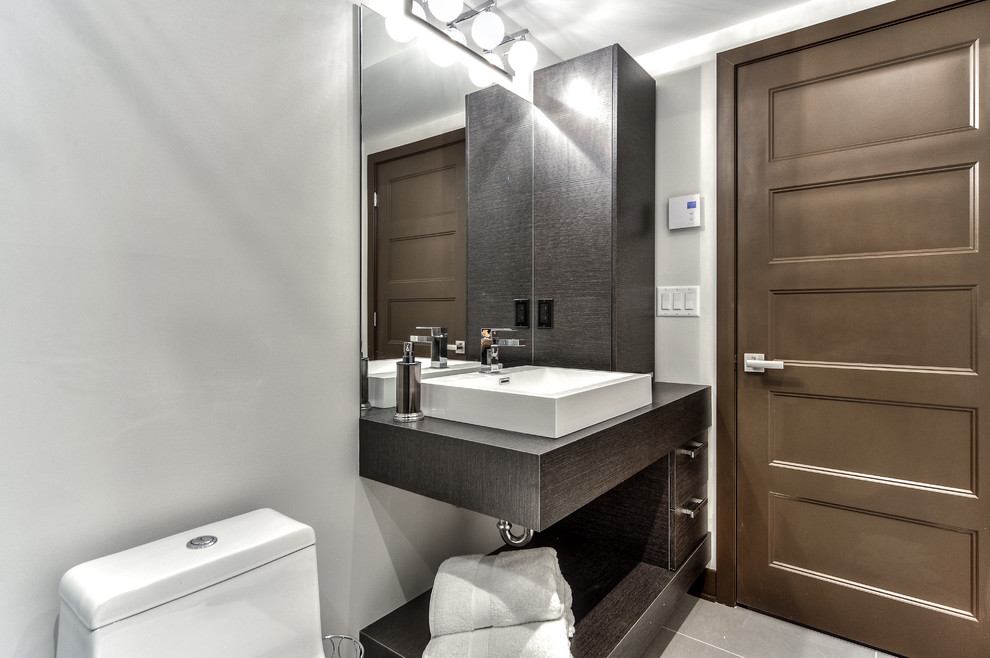 Inspiration pour une petite salle de bain minimaliste en bois foncé avec un placard à porte plane et un plan de toilette en stratifié.