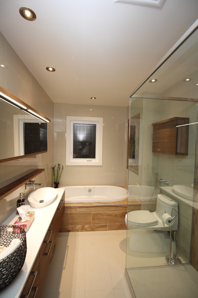 Design ideas for a medium sized modern ensuite bathroom in Montreal with flat-panel cabinets, medium wood cabinets, a built-in bath, an alcove shower, a one-piece toilet, brown tiles, porcelain tiles, beige walls, ceramic flooring, a vessel sink, solid surface worktops, beige floors and a hinged door.