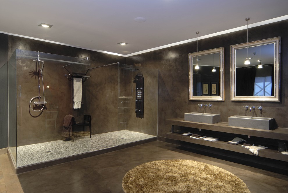 Modelo de cuarto de baño principal actual grande con armarios abiertos, ducha doble, paredes marrones, lavabo sobreencimera y microcemento