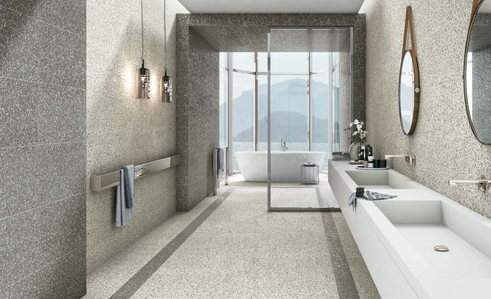 This is an example of a large modern ensuite bathroom in Miami with grey cabinets, a freestanding bath, a built-in shower, grey tiles, grey walls, an integrated sink, grey floors, grey worktops, double sinks and a floating vanity unit.