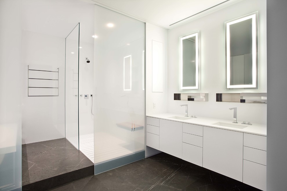Идея дизайна: большая главная ванная комната в стиле модернизм с плоскими фасадами, белыми фасадами, накладной ванной, унитазом-моноблоком, белой плиткой, керамогранитной плиткой, белыми стенами, бетонным полом, врезной раковиной, столешницей из искусственного кварца, черным полом, душевой комнатой и открытым душем