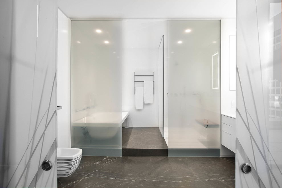 На фото: большая главная ванная комната в стиле модернизм с плоскими фасадами, белыми фасадами, накладной ванной, душевой комнатой, унитазом-моноблоком, белой плиткой, керамогранитной плиткой, белыми стенами, бетонным полом, столешницей из искусственного кварца, черным полом и открытым душем