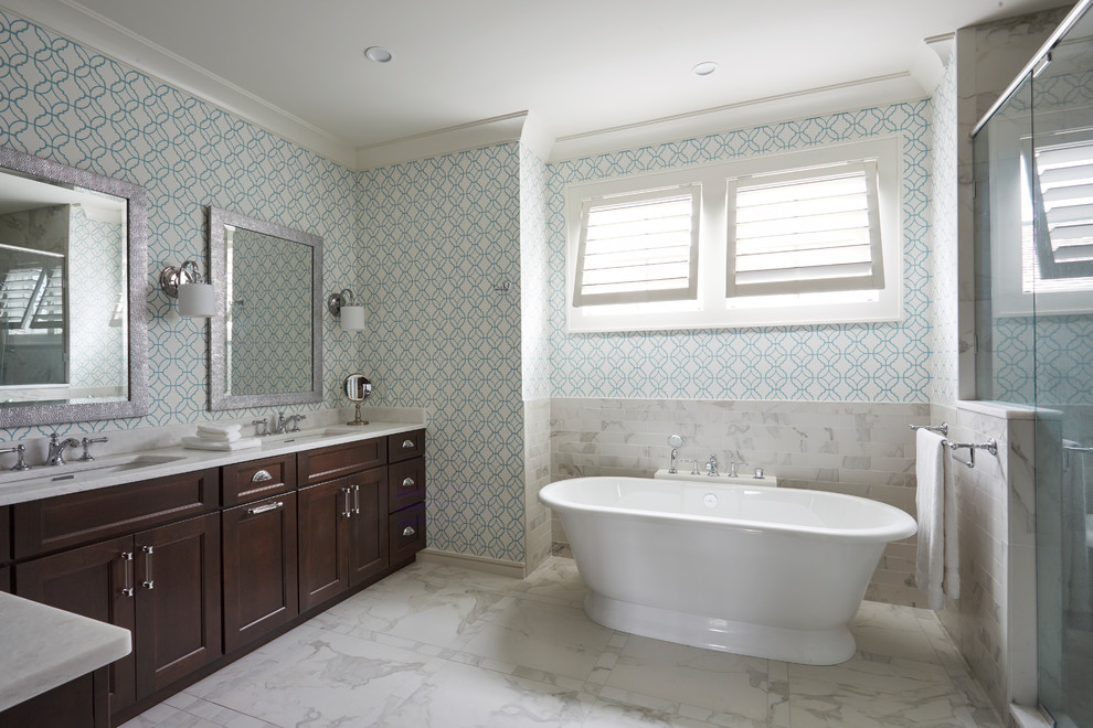 Example of a large beach style master white tile and porcelain tile porcelain tile and white floor bathroom design in Jacksonville with recessed-panel cabinets, dark wood cabinets, a one-piece toilet, blue walls, an undermount sink, marble countertops and a hinged shower door