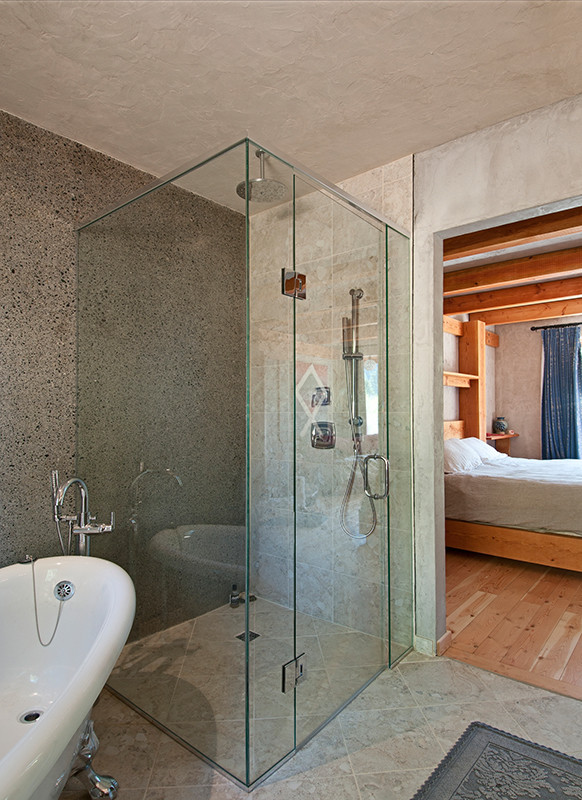 Cette photo montre une salle de bain principale montagne de taille moyenne avec une baignoire indépendante, une douche d'angle, un mur gris, une cabine de douche à porte battante, un carrelage noir, un carrelage gris et des carreaux de béton.