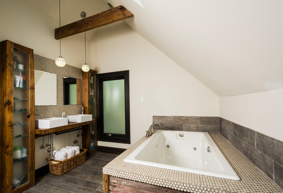 Bild på ett mellanstort industriellt en-suite badrum, med ett fristående handfat, öppna hyllor, skåp i mellenmörkt trä, träbänkskiva, en jacuzzi, grå kakel, stenkakel, vita väggar och mellanmörkt trägolv