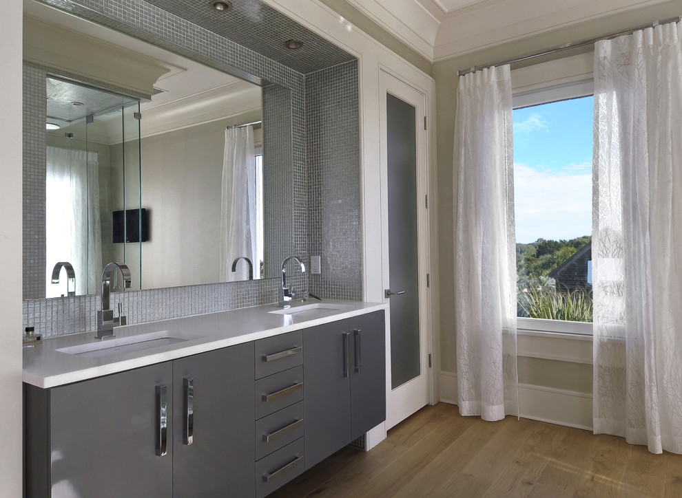 Foto de cuarto de baño rectangular contemporáneo con lavabo bajoencimera, armarios con paneles lisos, puertas de armario grises, baldosas y/o azulejos grises y baldosas y/o azulejos en mosaico