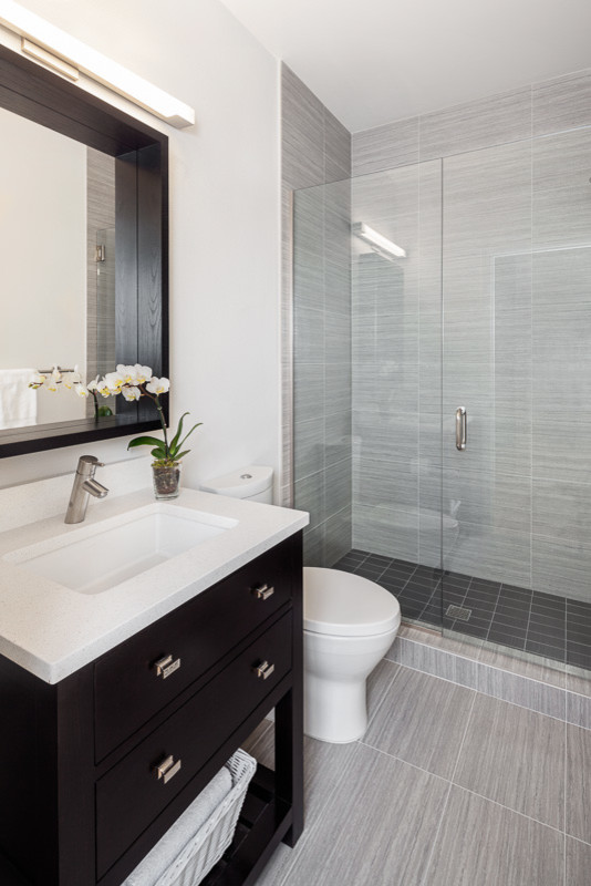 Foto de cuarto de baño tradicional renovado pequeño con lavabo bajoencimera, ducha empotrada, baldosas y/o azulejos grises y aseo y ducha