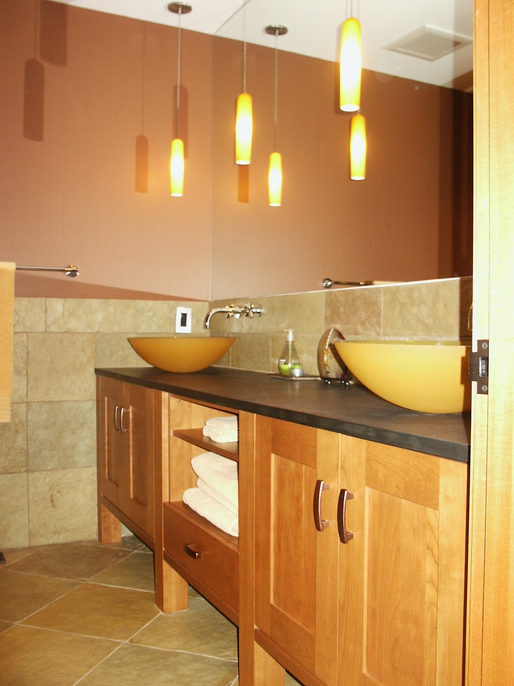 Inspiration pour une salle d'eau design en bois clair de taille moyenne avec un placard avec porte à panneau encastré, un plan de toilette en stéatite, un carrelage beige et un carrelage de pierre.