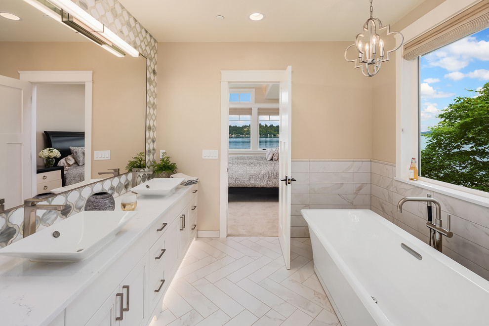 This is an example of a medium sized contemporary ensuite wet room bathroom in Seattle with recessed-panel cabinets, white cabinets, a built-in bath, multi-coloured tiles, ceramic tiles, beige walls, ceramic flooring, a built-in sink, marble worktops, a hinged door and white worktops.