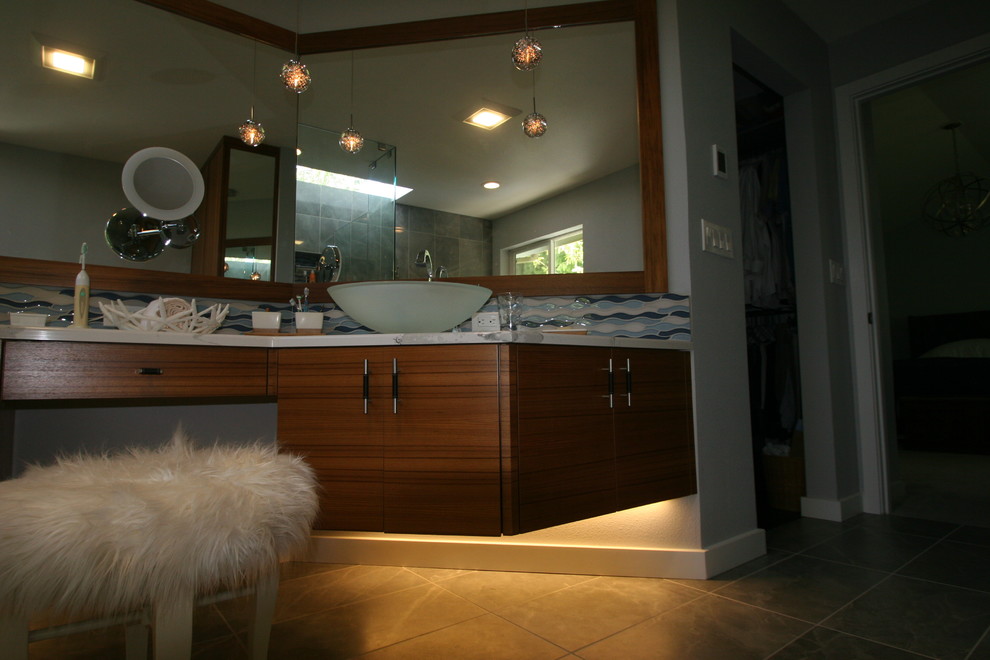 Cette photo montre une grande salle de bain principale moderne en bois brun avec un placard à porte plane, une baignoire indépendante, un espace douche bain, WC à poser, un carrelage bleu, un carrelage gris, un carrelage multicolore, un carrelage blanc, un carrelage de pierre, un mur blanc, un sol en carrelage de terre cuite, une vasque, un plan de toilette en marbre, un sol multicolore et une cabine de douche à porte battante.