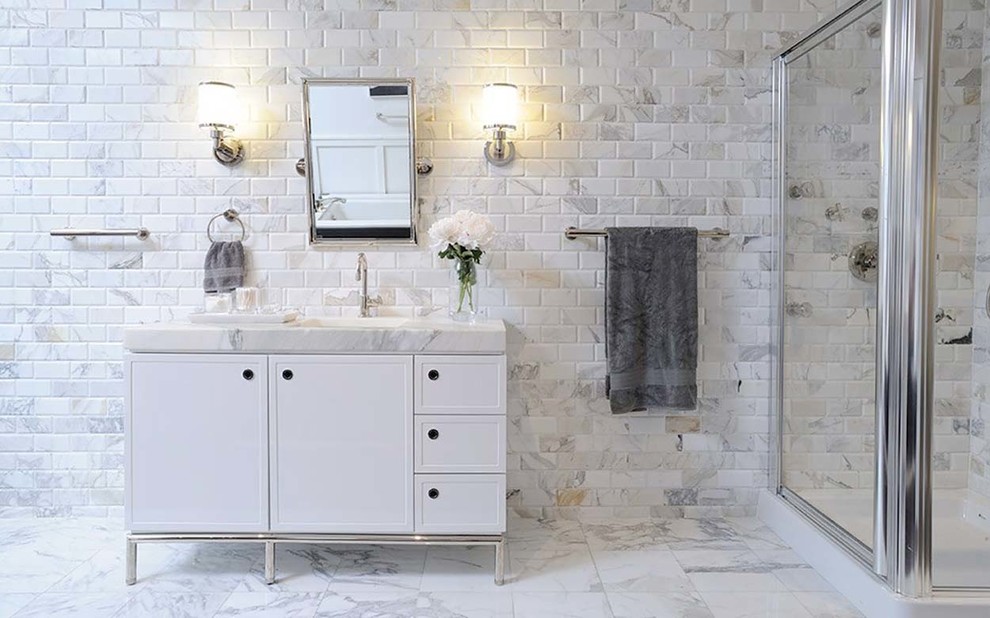 Cette image montre une grande salle de bain principale design avec une douche d'angle, un sol en marbre, un lavabo encastré, un sol blanc, une cabine de douche à porte battante, un placard en trompe-l'oeil, des portes de placard blanches, un carrelage gris, un carrelage blanc, du carrelage en marbre et un plan de toilette en marbre.
