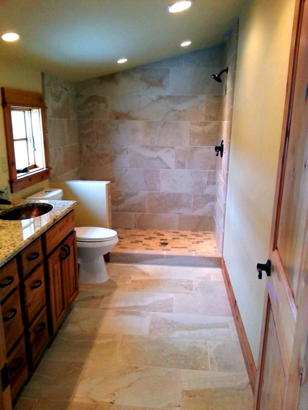 Imagen de cuarto de baño tradicional con puertas de armario de madera oscura, ducha empotrada, paredes beige, suelo de pizarra, lavabo bajoencimera y encimera de granito