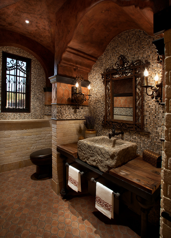 Foto de cuarto de baño mediterráneo con baldosas y/o azulejos en mosaico, encimera de madera, lavabo sobreencimera y encimeras marrones