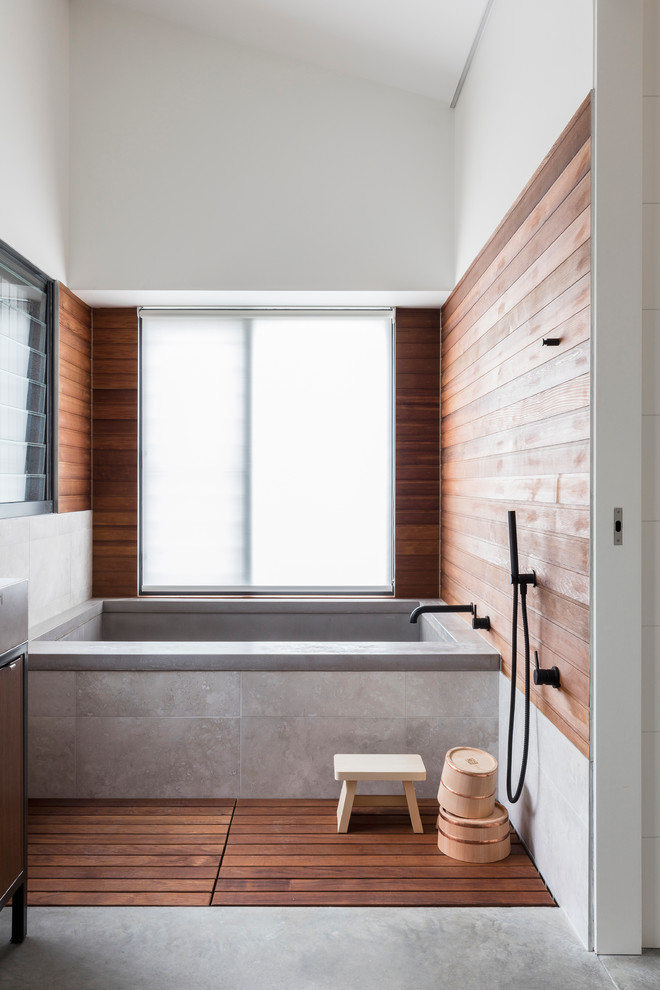 Modelo de cuarto de baño principal actual sin sin inodoro con bañera empotrada, paredes multicolor y suelo de cemento