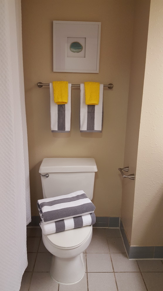Ispirazione per un bagno di servizio design di medie dimensioni con WC a due pezzi, pareti beige e pavimento con piastrelle in ceramica