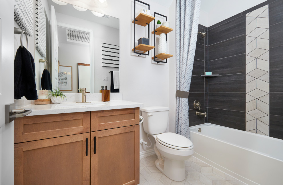 Cette image montre une salle de bain traditionnelle de taille moyenne pour enfant avec des portes de placard marrons, un combiné douche/baignoire, un carrelage noir, des carreaux de céramique, un mur blanc, un sol en carrelage de céramique, un lavabo encastré, un plan de toilette en surface solide, un sol beige, une cabine de douche avec un rideau, un plan de toilette blanc, meuble simple vasque, un placard à porte shaker, une baignoire en alcôve et meuble-lavabo encastré.