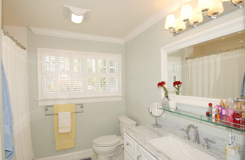 Example of a classic beige tile, gray tile, white tile and ceramic tile porcelain tile and white floor bathroom design in San Francisco with beaded inset cabinets, white cabinets, a two-piece toilet, blue walls, an undermount sink and marble countertops