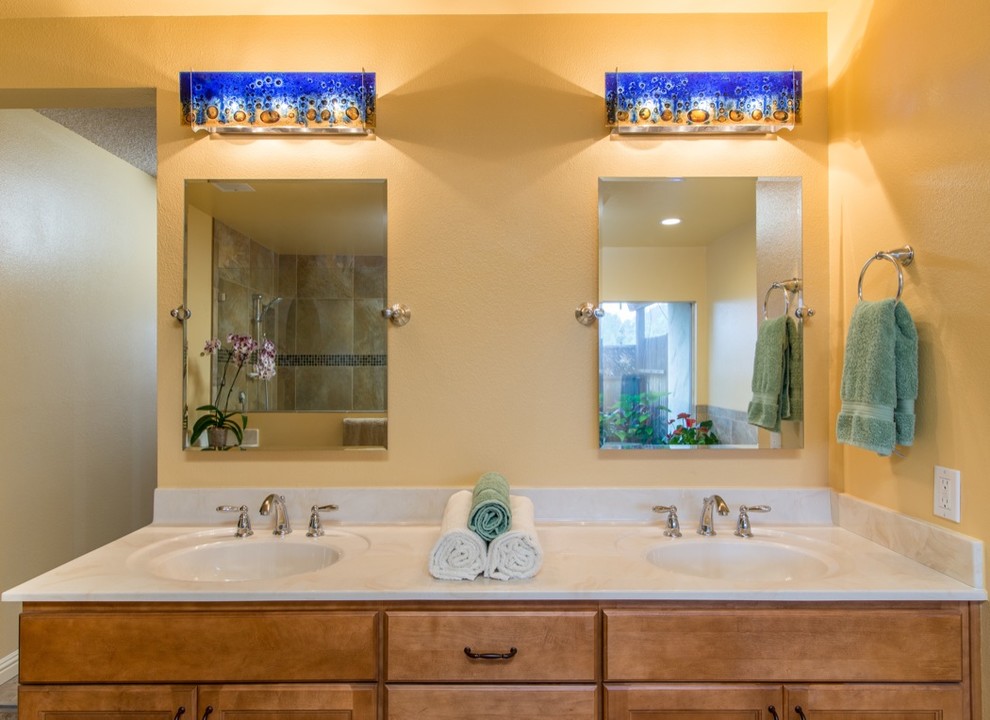 Exotisk inredning av ett stort en-suite badrum, med släta luckor, skåp i ljust trä, ett platsbyggt badkar, en dusch i en alkov, brun kakel, glaskakel, gula väggar, linoleumgolv, ett integrerad handfat och marmorbänkskiva