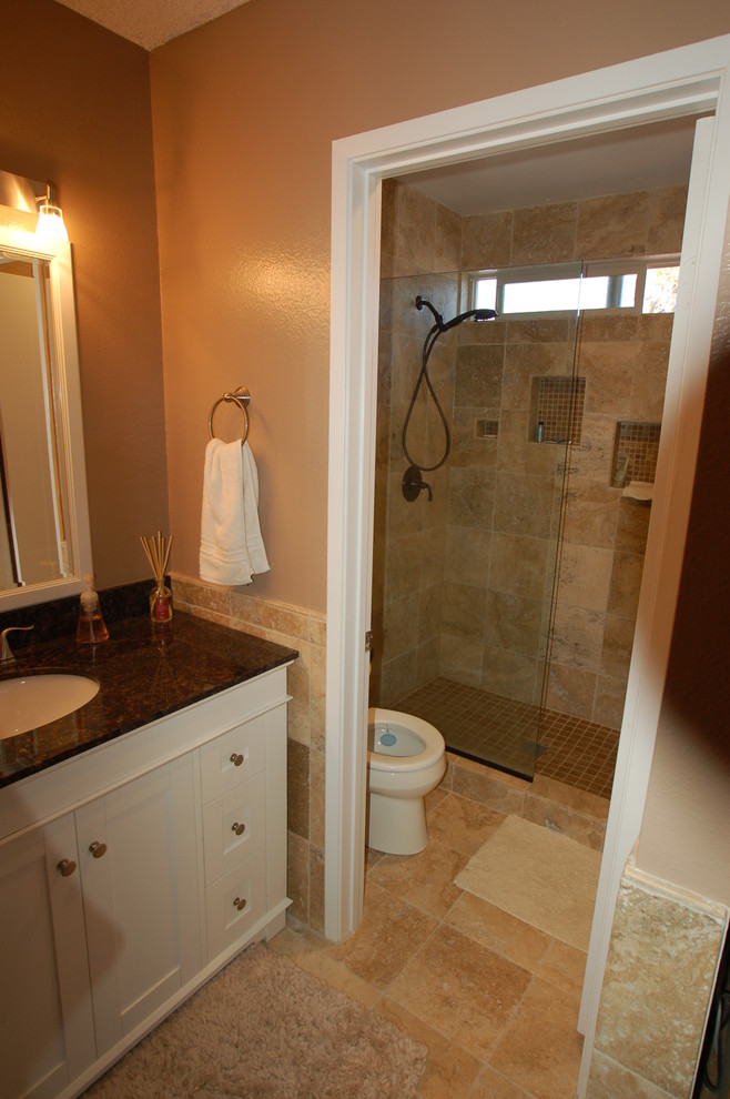Doorless shower - mid-sized traditional 3/4 beige tile, brown tile and ceramic tile doorless shower idea in San Diego with shaker cabinets, white cabinets, a one-piece toilet, beige walls, an undermount sink and granite countertops