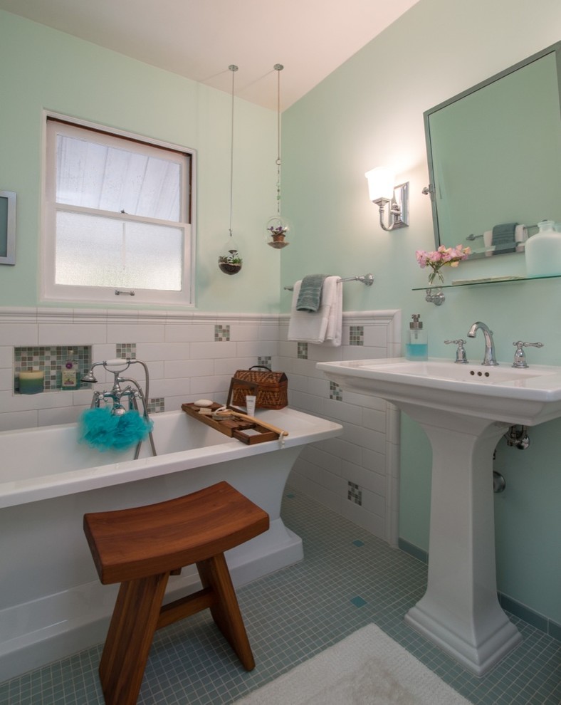 Klassisk inredning av ett litet badrum, med ett piedestal handfat, ett fristående badkar, gröna väggar och mosaikgolv