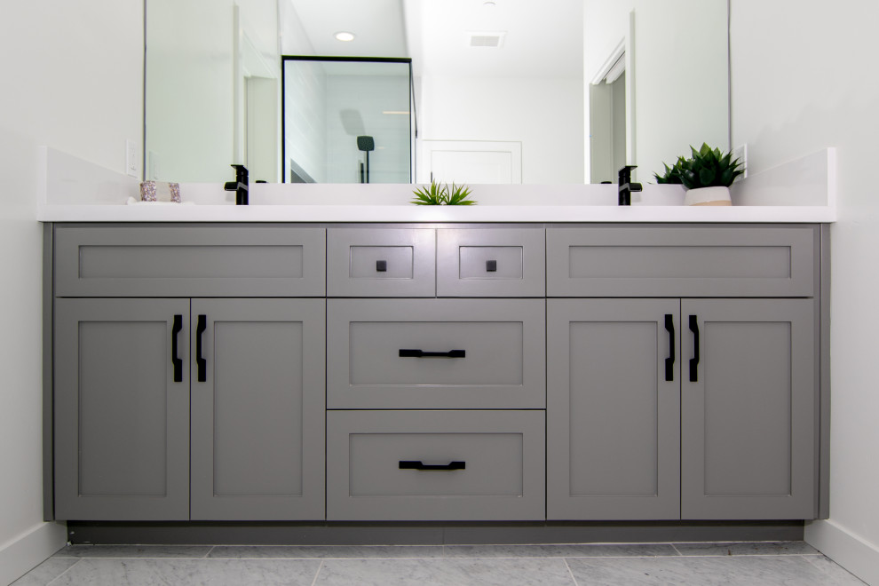 Idéer för att renovera ett stort funkis vit vitt en-suite badrum, med luckor med infälld panel, grå skåp, ett hörnbadkar, en hörndusch, en toalettstol med separat cisternkåpa, vit kakel, glaskakel, vita väggar, klinkergolv i keramik, ett integrerad handfat, bänkskiva i kvarts, flerfärgat golv och dusch med gångjärnsdörr