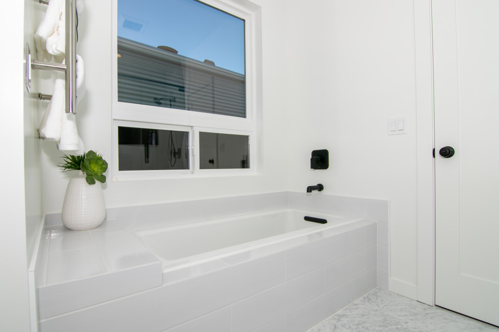 Inspiration for a large modern master corner bathtub remodel in San Diego with white walls