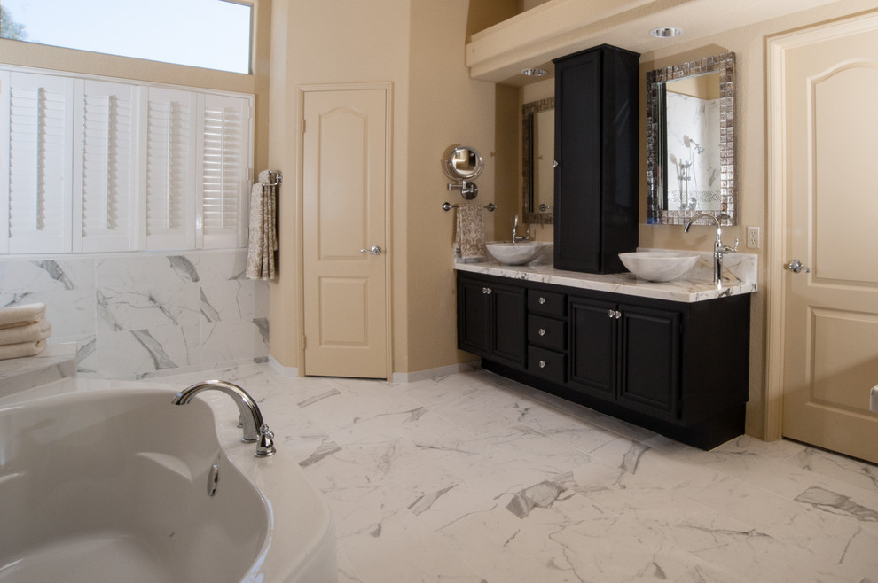 Example of a large transitional master black and white tile and ceramic tile ceramic tile bathroom design in San Diego with recessed-panel cabinets, dark wood cabinets, a two-piece toilet, white walls, a vessel sink and marble countertops