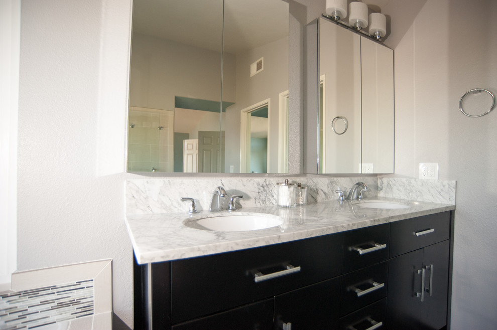 Example of a large transitional master black tile and ceramic tile ceramic tile, black floor, double-sink and vaulted ceiling bathroom design in San Diego with flat-panel cabinets, dark wood cabinets, a two-piece toilet, white walls, a drop-in sink, quartzite countertops, a hinged shower door, white countertops and a built-in vanity