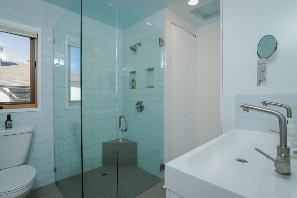 На фото: маленькая ванная комната в морском стиле с угловым душем, синей плиткой, стеклянной плиткой, белыми стенами и раковиной с несколькими смесителями для на участке и в саду с