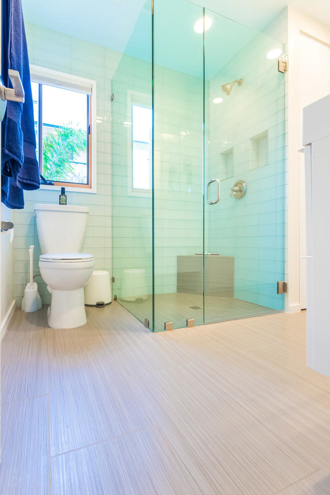 На фото: маленькая ванная комната в морском стиле с угловым душем, синей плиткой, стеклянной плиткой, белыми стенами и раковиной с несколькими смесителями для на участке и в саду