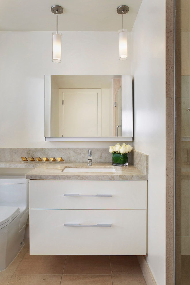 Réalisation d'une salle de bain design avec un placard à porte plane, des portes de placard blanches, WC à poser, un mur blanc et un lavabo encastré.