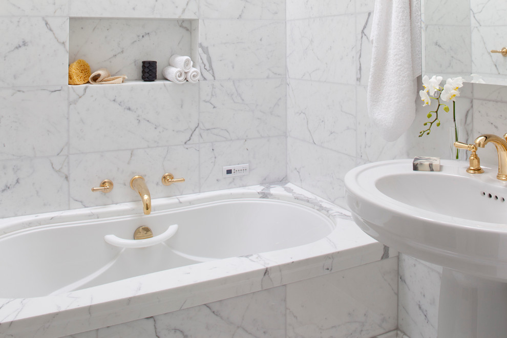 Diseño de cuarto de baño principal clásico de tamaño medio con lavabo con pedestal, jacuzzi, combinación de ducha y bañera, sanitario de una pieza, baldosas y/o azulejos blancos, baldosas y/o azulejos de piedra, paredes blancas y suelo de mármol